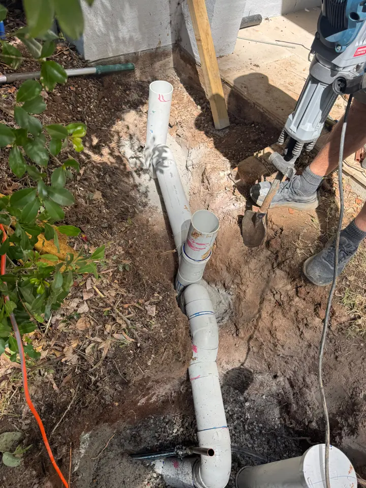 Excavated underground drain being replaced with drainage-grade pipe